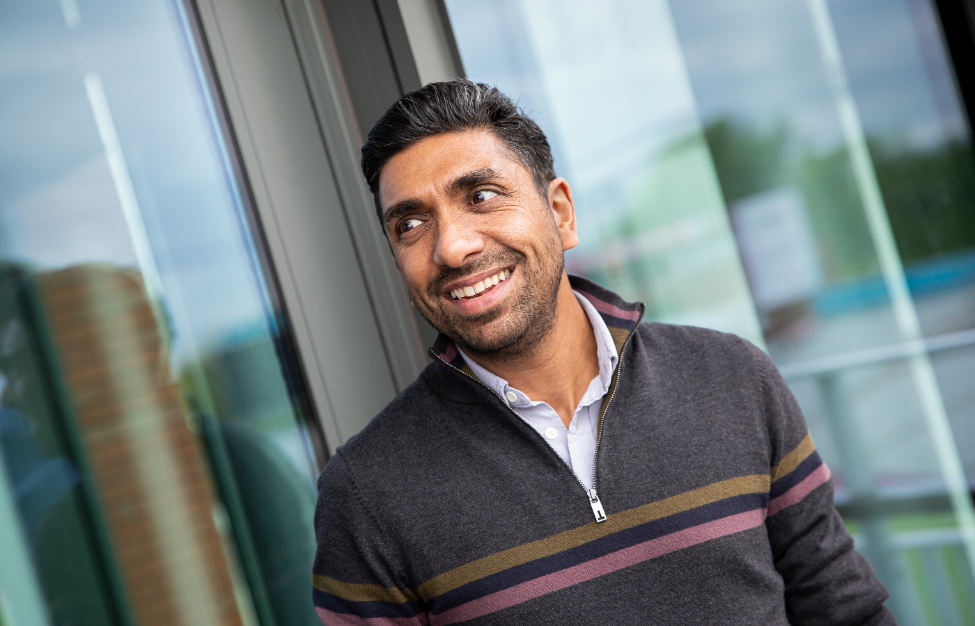 a man standing in front of a window smiling.