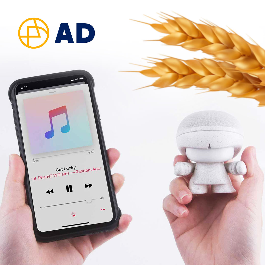 A smartphone playing a song alongside a small figurine and some wheat